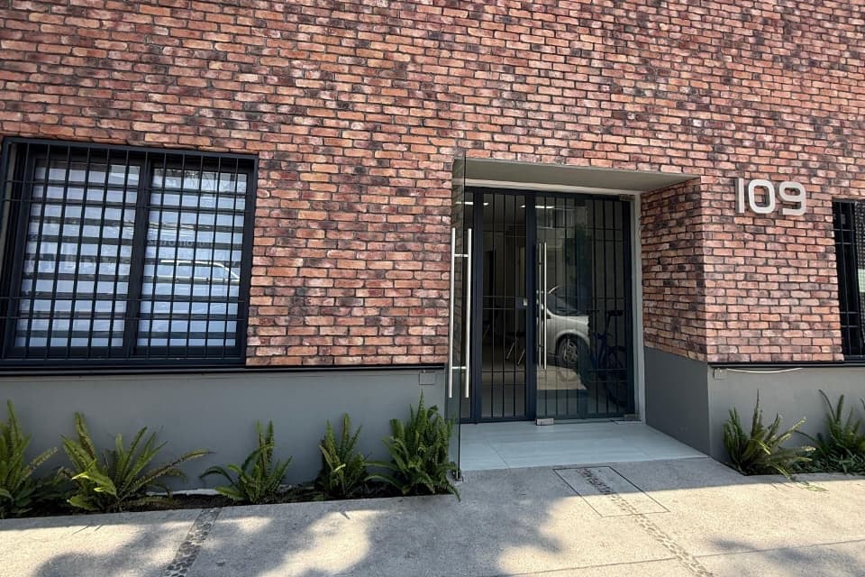 Fachada de ladrillo del consultorio, con el número 109 junto a la puerta
